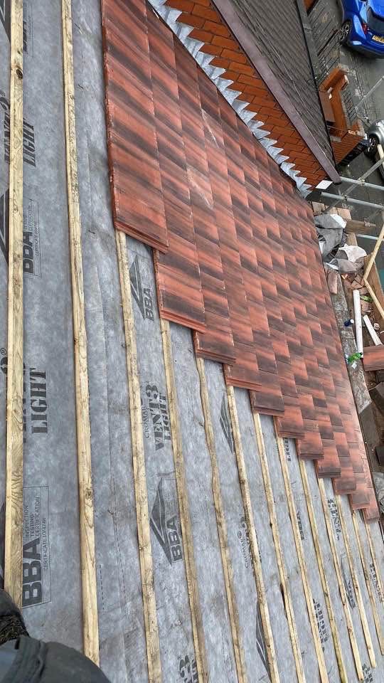 New clay roof tiles being installed over insulation and timber battens