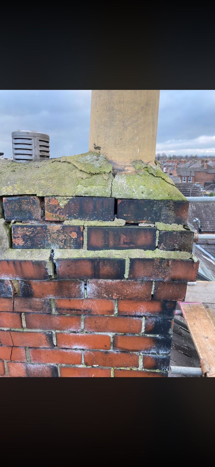 Deteriorating brick chimney and pot with cracked mortar prior to repair