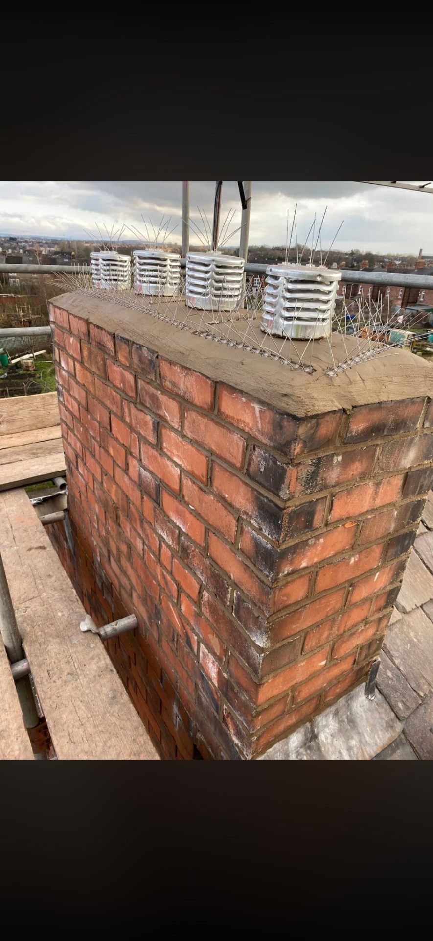Brick chimney with four pots and stainless bird spikes after repair