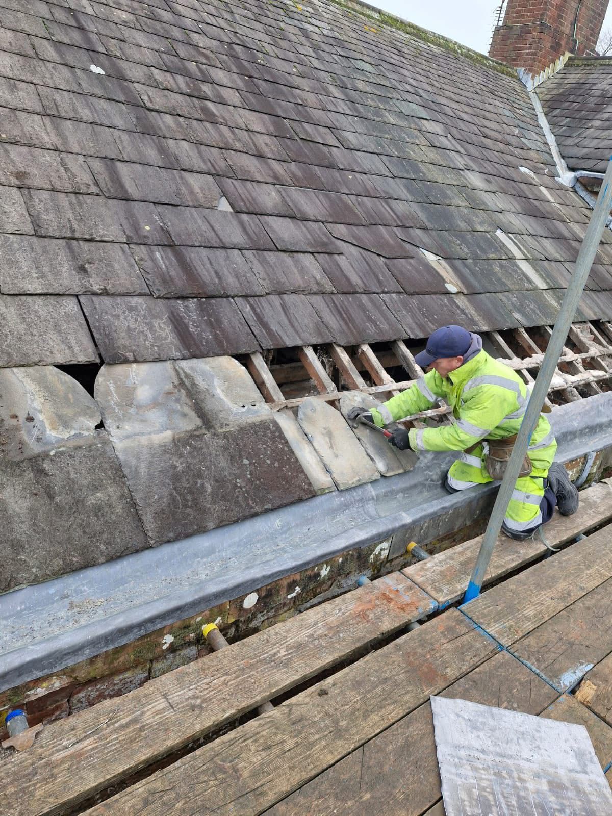 Slate roof repair in progress with new leadwork and exposed battens