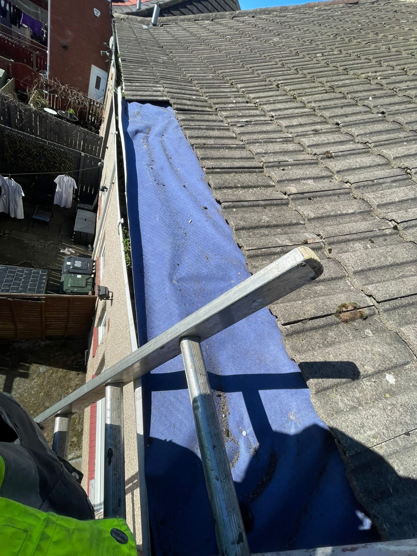 Pitched roof with blue underlayment exposed during repair works